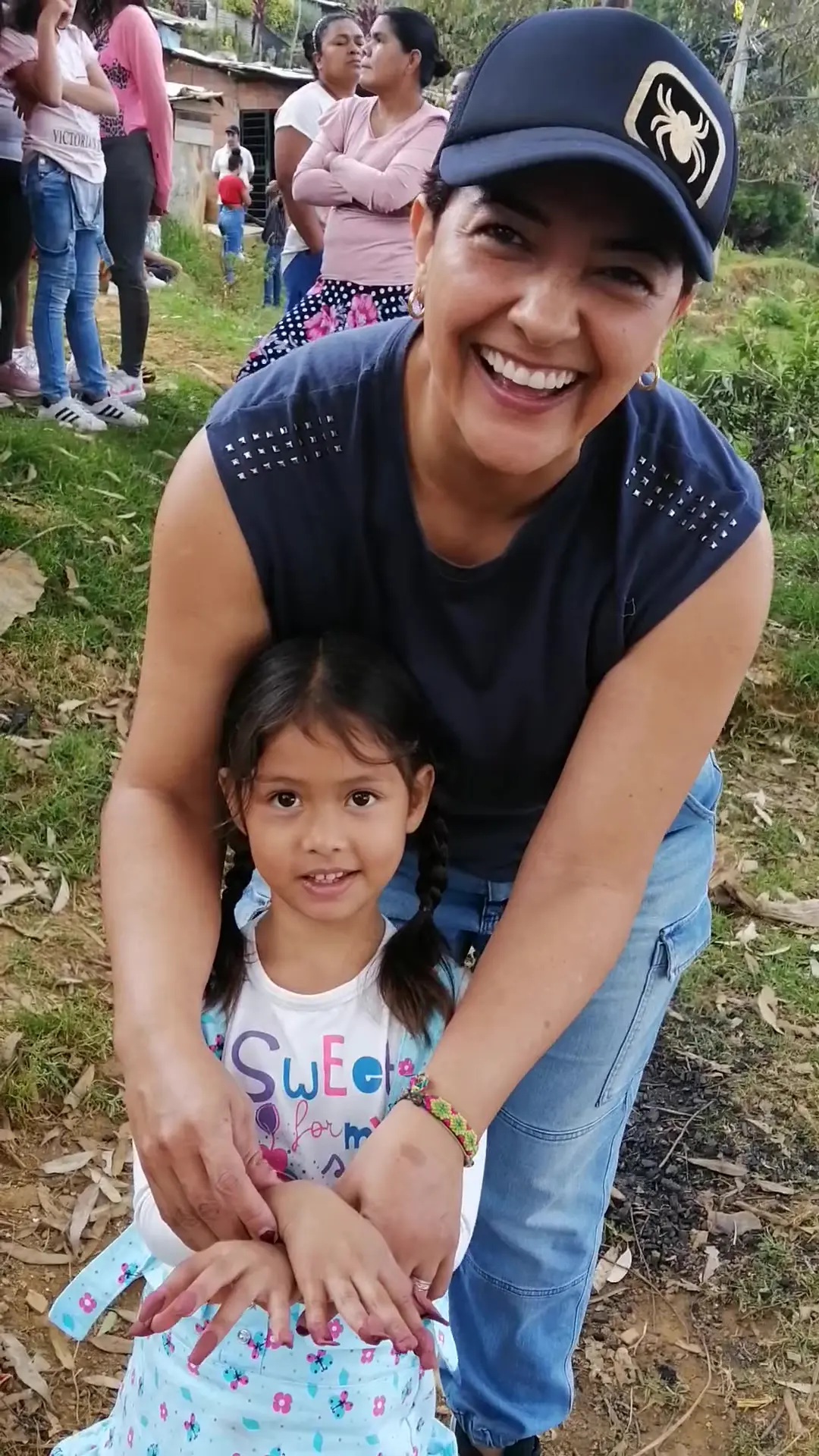 Hepacom volunteer hugging a girl from the community